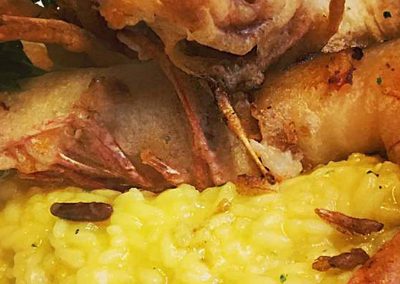Risotto zafferano e pinoli con gamberoni in tempura